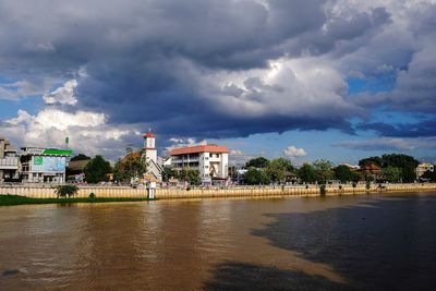 Buildings in city against cloudy sky