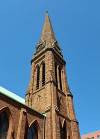 Low angle view of clock tower against blue sky