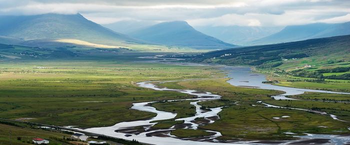 Scenic view of river and mountains against sky