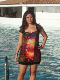 Portrait of a smiling young woman standing in water