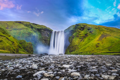 Scenic view of waterfall against sky