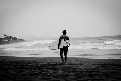 Full length of man on beach against clear sky