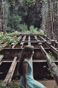Woman sitting on abandoned bridge