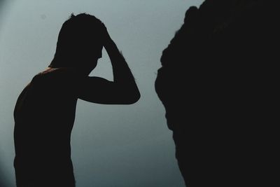 Side view of silhouette couple standing against sky