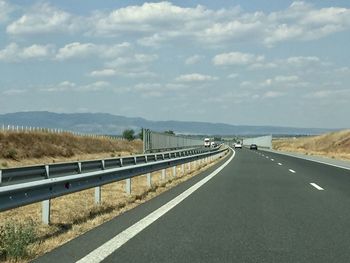 Road leading towards mountain against sky