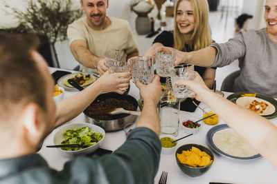 Group of friends raising toast during mexican feast