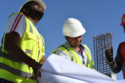 Low angle view of man working against sky