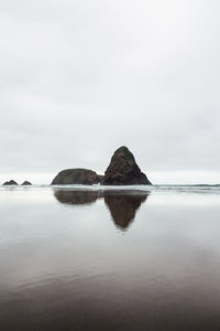 Rock formation in sea against sky