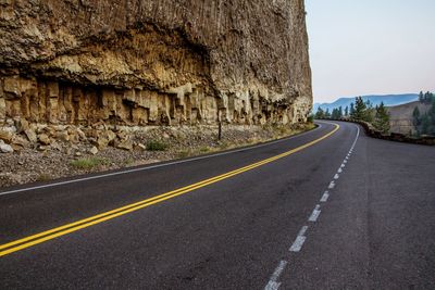 Empty mountain road by cliff