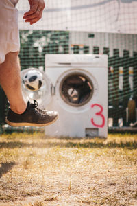 Low section of man kicking a ball 