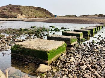 Stone wall by sea against clear sky