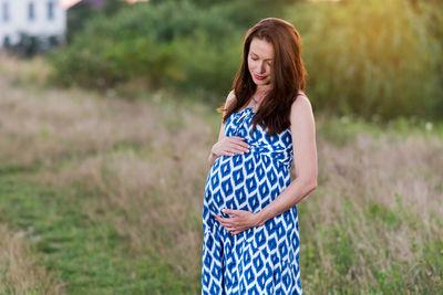 Pregnant young woman smiling outdoors