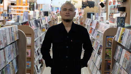 Portrait of young man standing at store