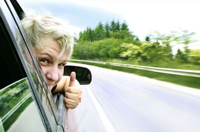 Portrait of boy in car on road