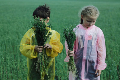 Rear view of siblings standing in water