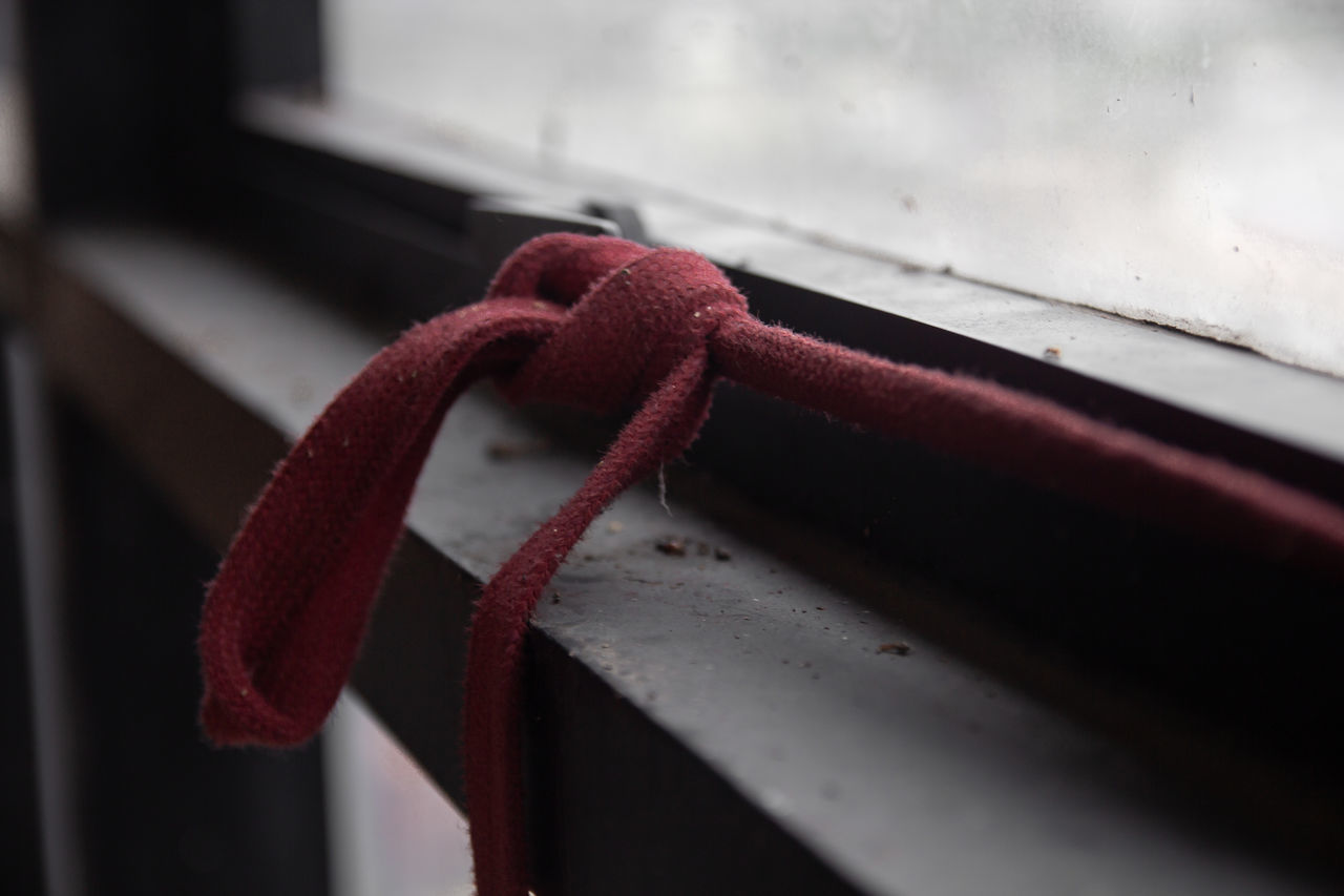 CLOSE-UP OF ROPE TIED UP ON RAILING