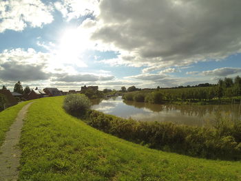 Scenic view of grassy field against cloudy sky