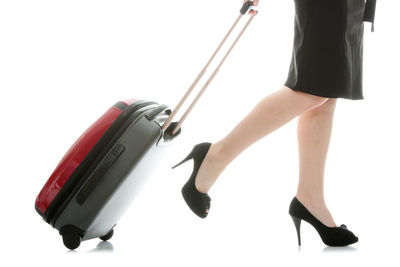 Low section of woman walking on floor against white background