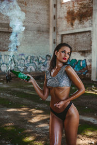 Portrait of woman standing against wall