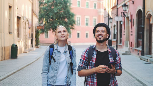 Portrait of smiling young man standing on street in city