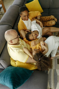 Smiling parents with daughter and son enjoying at home