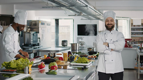 Portrait of smiling chef standing in kitchen