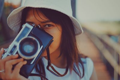 Portrait of young woman holding camera