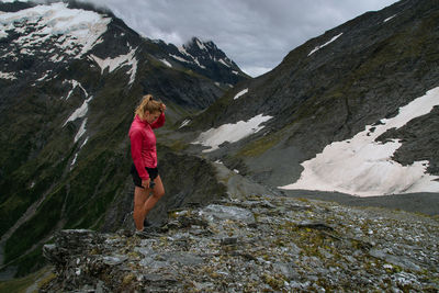 Woman standing on rock against mountains