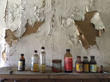 Multi colored bottles on table against wall