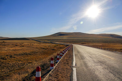 Road amidst field against sky