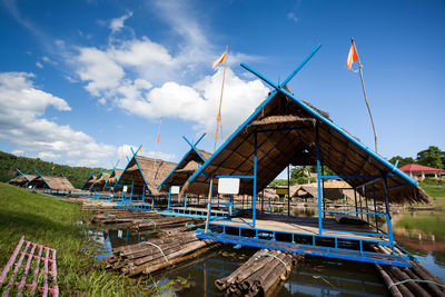 Traditional building by lake against sky