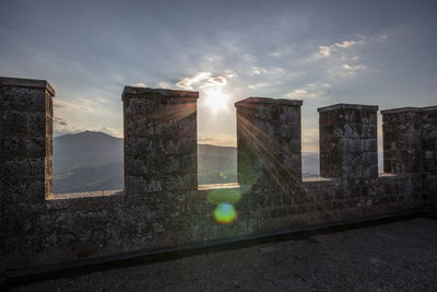 Fortified wall on castle against bright sky