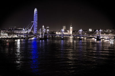 Golden jubilee bridge over thames river with illuminated london eye