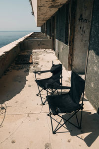 Empty chairs and table at beach