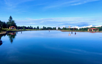 Scenic view of swimming pool by lake against sky