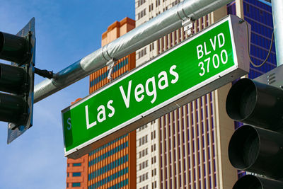 Low angle view of road sign against built structures