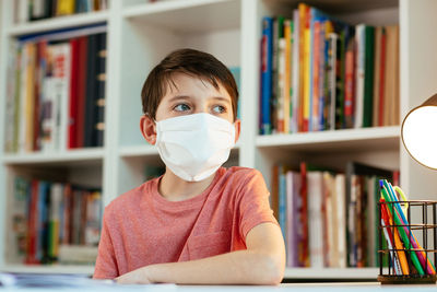 Portrait of boy wearing book at home