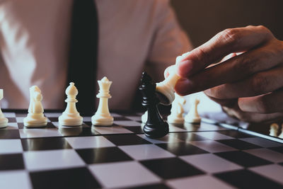 Close-up of man playing on chess board