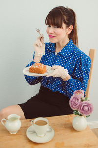 Portrait of smiling woman having breakfast at table