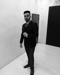 Portrait of young man standing on tiled floor