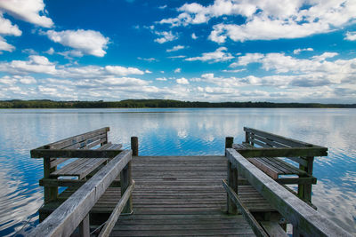 Empty pier on lake against sky