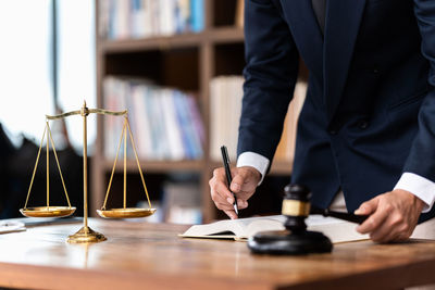 Midsection of lawyer working at desk in courtroom