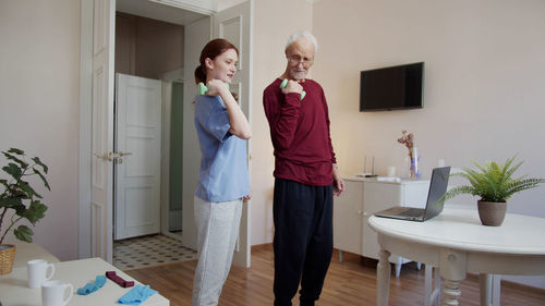 Nurse and senior man exercising at nursing home