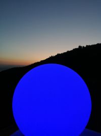 Silhouette landscape against clear blue sky during sunset