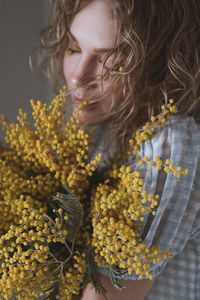 Close-up of woman with yellow flowers