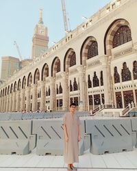 Rear view of woman standing against historic building