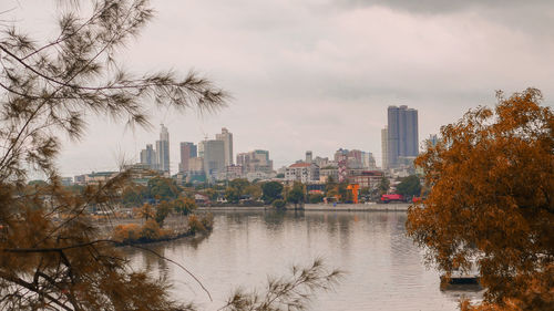 River amidst buildings in city against sky