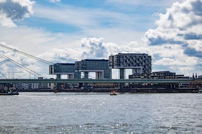 Bridge over river in city against sky