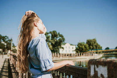 Side view of girl standing against clear sky