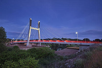 Suspension bridge against sky at dusk